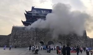 Tourists scramble as 600-year-old Chinese tower partially collapses.