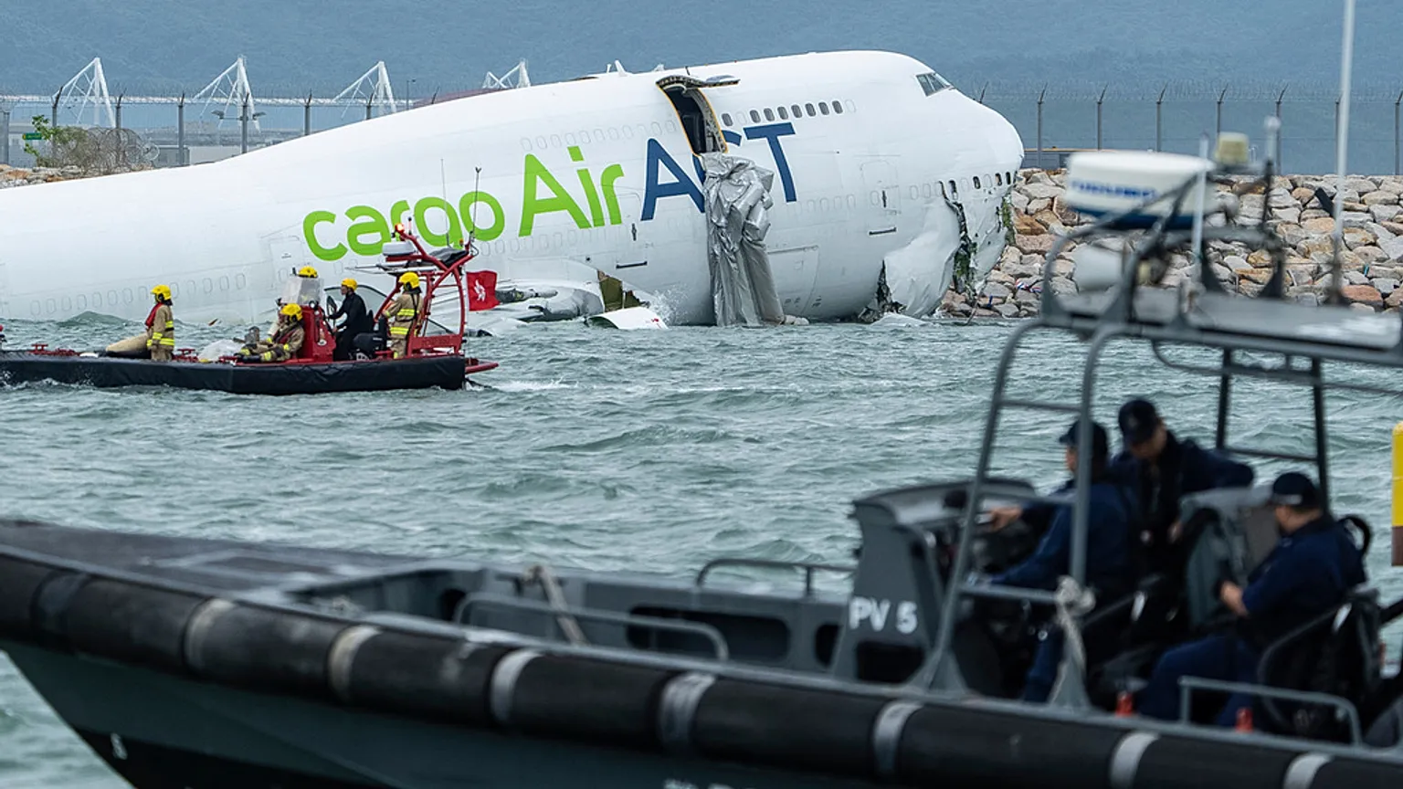 Two dead after cargo plane skids off Hong Kong runway into sea.