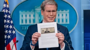 Treasury Secretary Scott Bessent holds up a news article with a mock-up of a possible Trump bill.