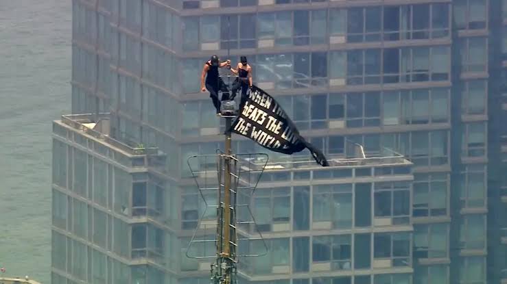 Russian daredevils unfurl banner atop New York's Empire State Building in proposal stunt.