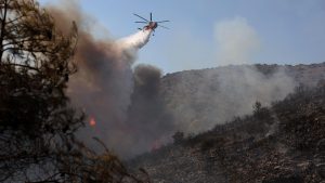 Two dead and hundreds evacuated after twin fires break out on Greek island.