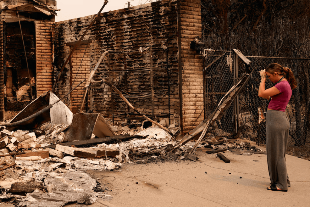 Ash Sollie looks at her grandparents' home, where she previously lived, after it was destroyed by a wildfire, in Spokane, Washington, U.S., August 2, 2026.