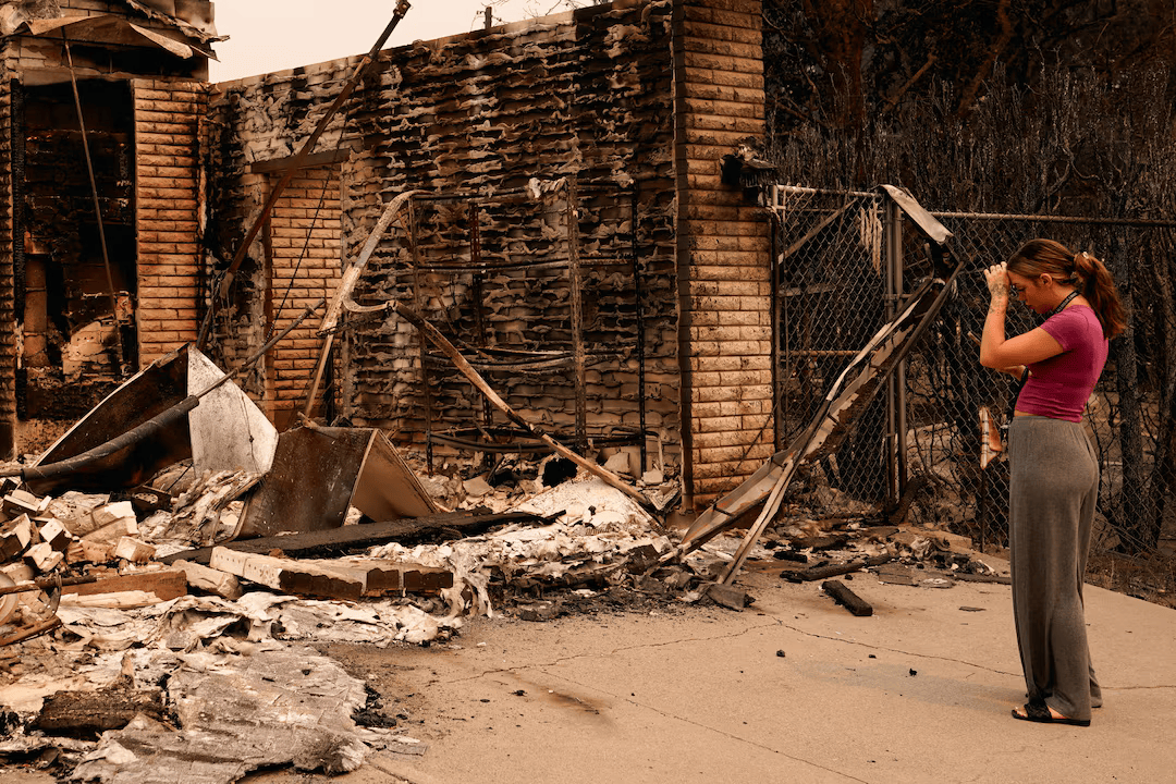 Ash Sollie looks at her grandparents' home, where she previously lived, after it was destroyed by a wildfire, in Spokane, Washington, U.S., August 2, 2026.