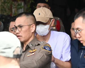 Police officers escort Phra Wachirayan Wi outside the Central Investigation Bureau in Bangkok on Thursday.