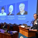 The three recipients, (from left) Karl Deisseroth, Peter Hegemann and Georg Nagel are shown on screen during the Nobel prize announcement.