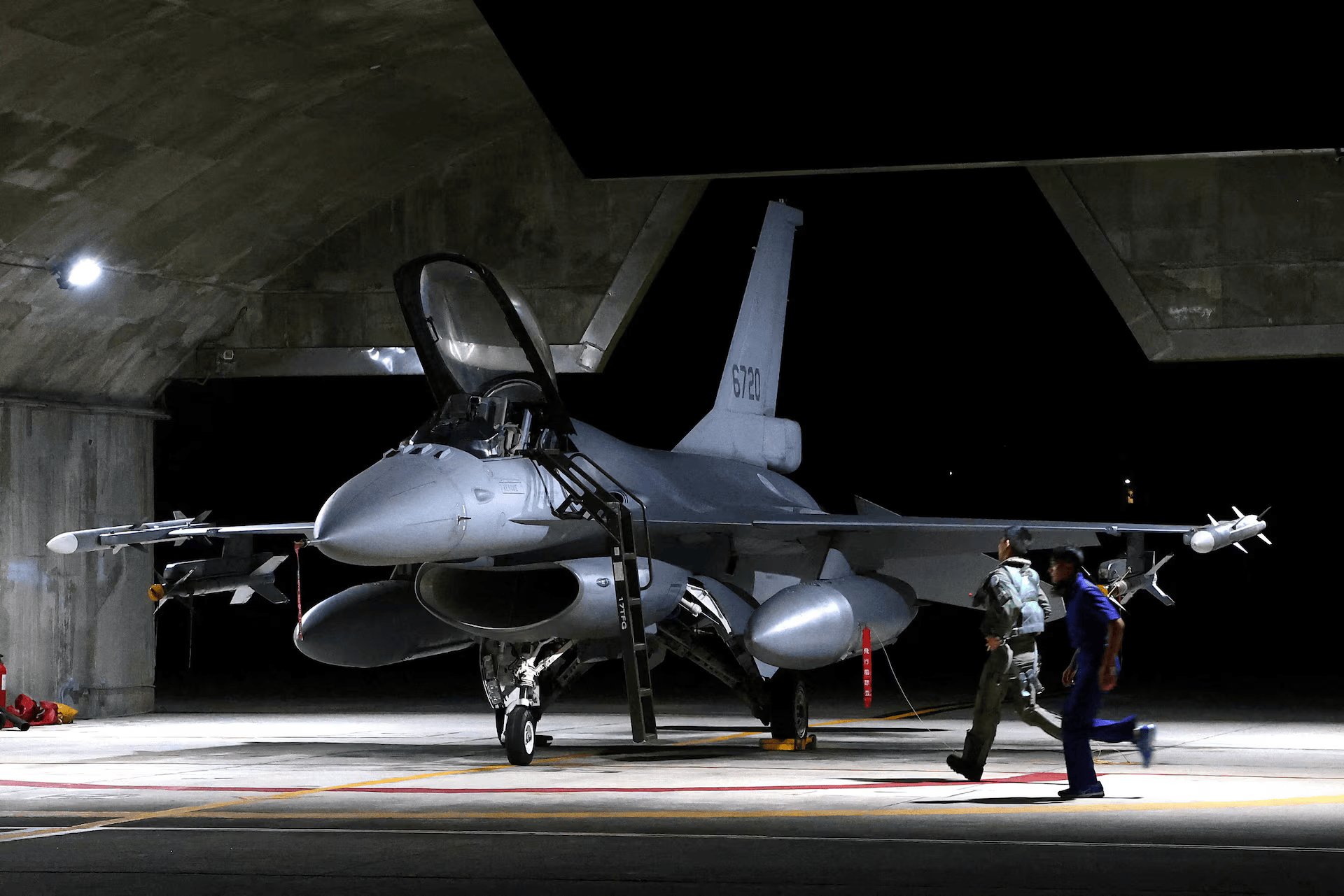 A pilot and Air Force soldier run towards a F-16V fighter jet for an evening take off as part of a combat readiness mission at the airbase in Hualien, Taiwan, August 17, 2022.