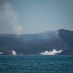 Mount Anak Krakatau billows smoke from its crater and lava flows send up clouds of steam as they reach the sea, as seen from the waters of the Sunda Strait on Sept. 12.